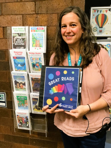 Woman holding Great Reads book list binder.