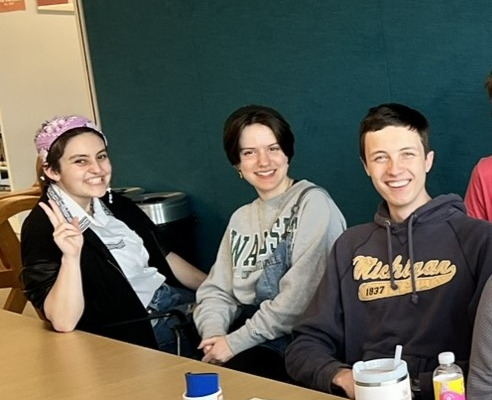 Want to make the library a great place for teens? Join TAB! Three teens sit at a table, smiling.