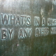 Photograph of a bronze plaque that contains the text "What's in a name? That which we call a rose By any other word would smell as sweet."